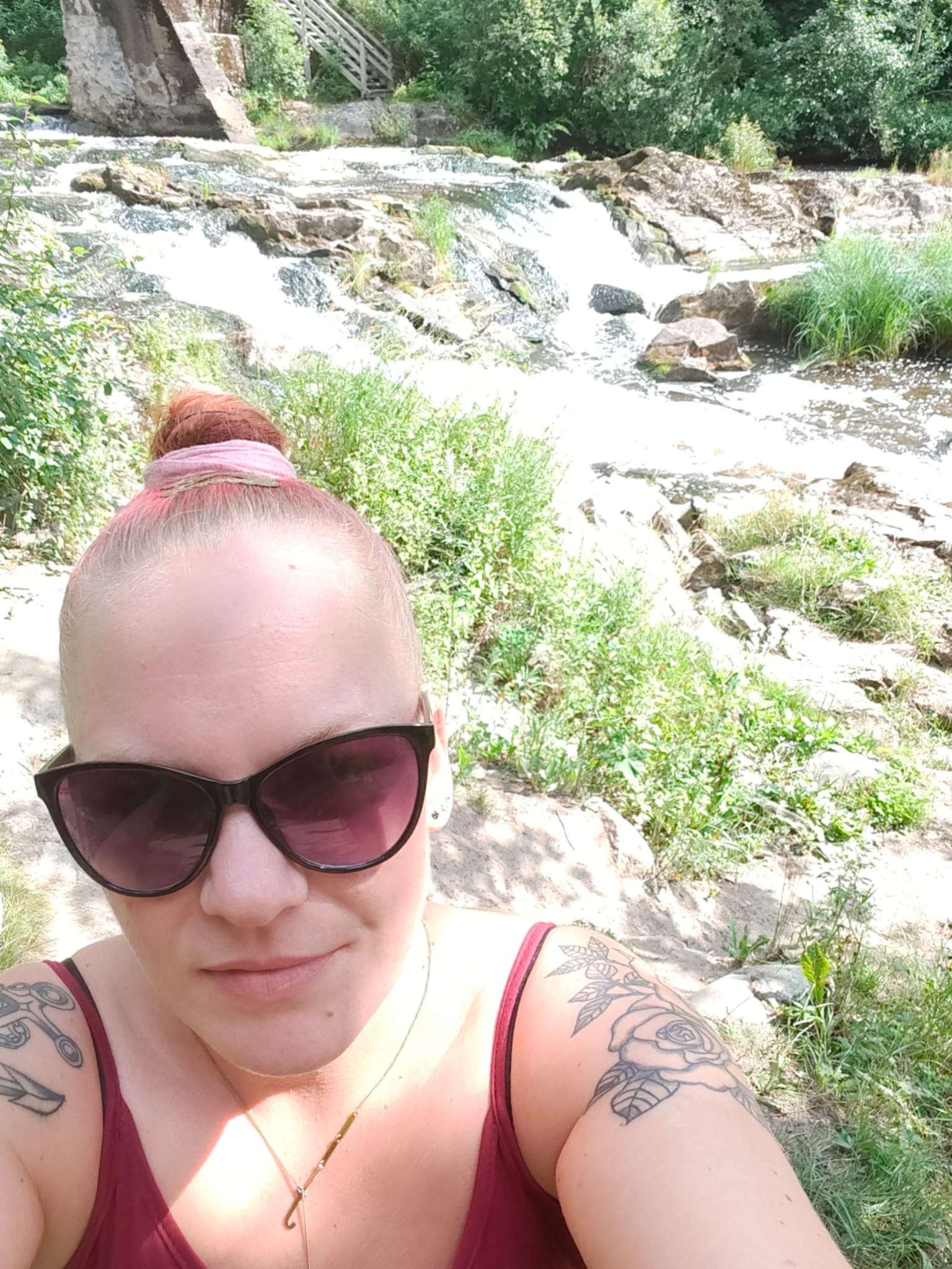 Henkilön kasvot. Taustalla koskimaisema.